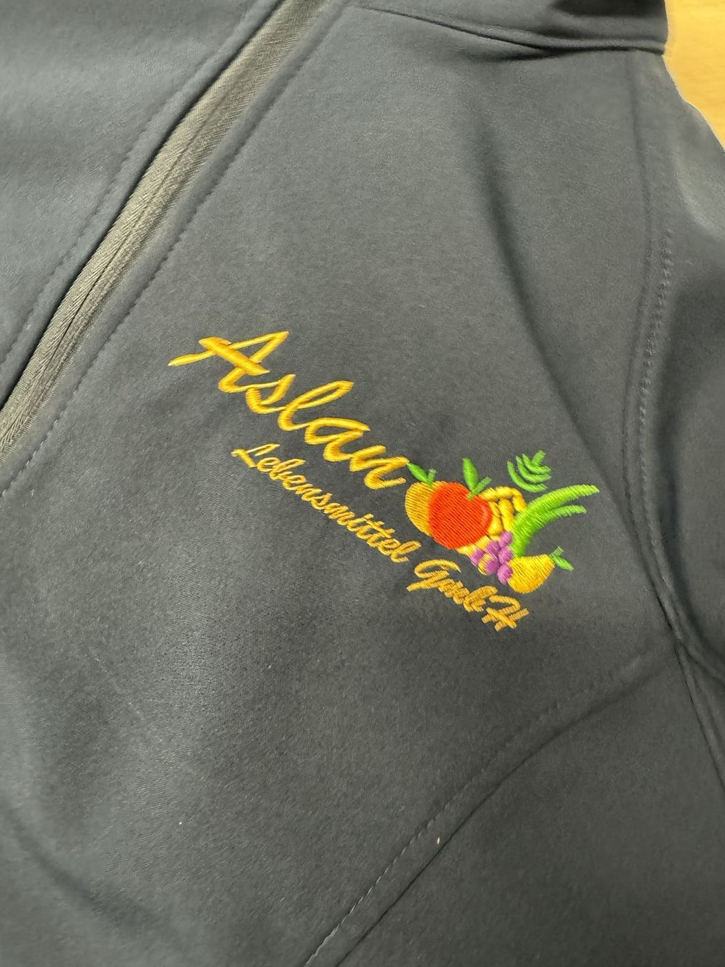 Stickerei · Firmenlogo auf Softshelljacke